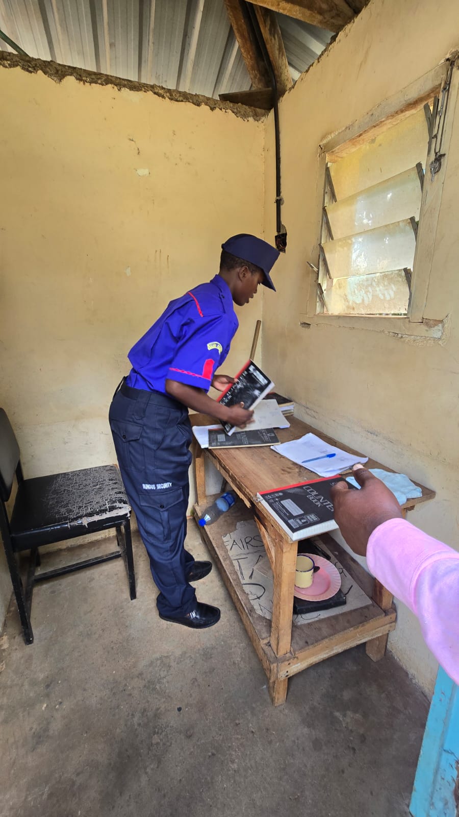 Supervisor checking the occurrence book at a guard post